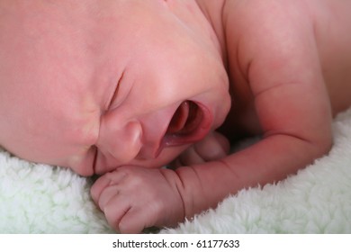 Caucasian New Born Baby Girl Crying On A Green Blanket