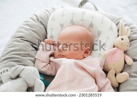 Caucasian Newborn baby sleeping in a baby lounger. Baby nest. 