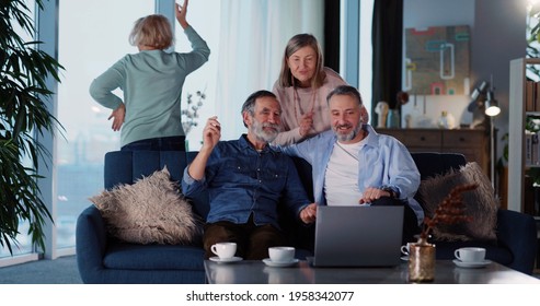 Caucasian Old Friendly Men And Women Dancing Watching Music Concert TV Show On Large Monitor In The Living Room. Relationships. Old Friends.