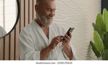 Caucasian old retired man mature senior male in bathrobe morning home hotel bathroom reading smartphone message mobile phone browsing amazed shocked wonder say wow amazing good news cellphone achieve - Powered by Shutterstock