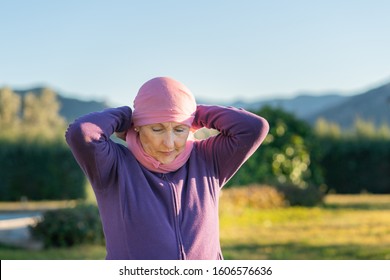 Caucasian Older Woman Putting A Pink Scarf On Her Head