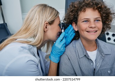 Caucasian Pediatrician Examining Curly Boy Using Otoscope, Hearing Check-up For Child. Hearing Exam