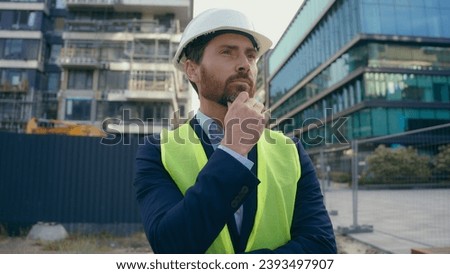 Caucasian pensive adult man heavy metal building industry worker inspector thinking architect looking at skyscrapers contractor think engineer in hardhat thoughtful dissatisfied frustrated problem