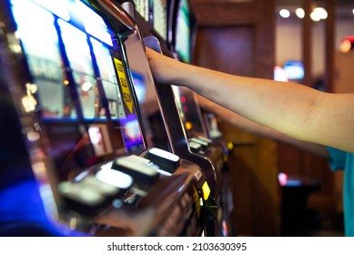 Caucasian People Playing Classic Casino Slot Machines Close Up Photo. Las Vegas Gambling Theme.