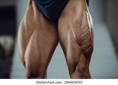 Caucasian power athletic man training pumping up leg quadriceps muscles. Strong bodybuilder with six pack, perfect abs, triceps, chest, shoulders in gym. Fitness and bodybuilding concept