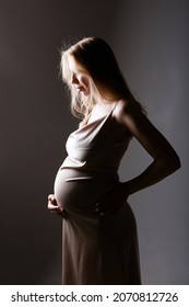 caucasian pregnant woman stroking her belly on white background. Copy space. The concept of healthy digestion, lifestyle, IVF