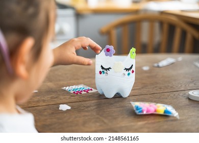 Caucasian Preschool Girl Doing Crafts With Plastic Bottle And Paints. Recycle Upcycling Waste. Sustainable Lifestyle