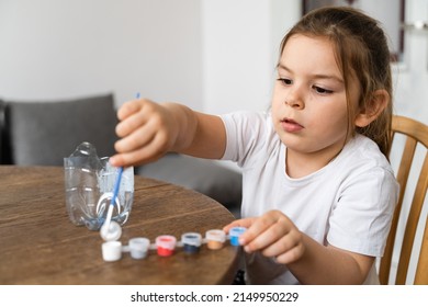 Caucasian Preschool Girl Doing Crafts With Plastic Bottle And Paints. Recycle Upcycling Waste. Sustainable Lifestyle