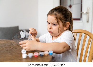 Caucasian Preschool Girl Doing Crafts With Plastic Bottle And Paints. Recycle Upcycling Waste. Sustainable Lifestyle