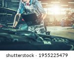 Caucasian Professional Automotive Mechanic in His 40s Making Documentation Inside Authorized Dealership Service Center. Vehicles Scheduled Maintenance.