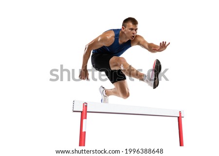 Caucasian professional male athlete jumping over the barrier isolated on white background. Running with obstacles concept. Muscular man. Action, motion, healthy, sport and lifestyle. Copyspace for ad.
