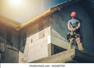 Caucasian Project Manager Supervising House Construction. Construction Site Supervisor Taking Look on the Building From Outside. Residential Construction.