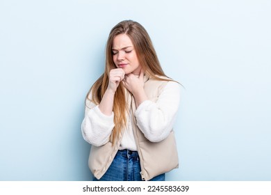 caucasian red hair woman feeling ill with a sore throat and flu symptoms, coughing with mouth covered - Shutterstock ID 2245583639