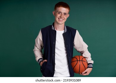Caucasian Red Head Boy Holding Basketball Ball And Looking At Camera
