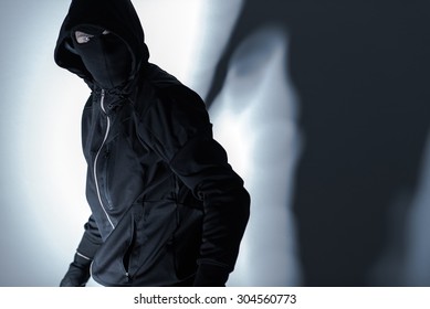 Caucasian Robber In Black Mask And Black Gloves Preparing For Robbery.