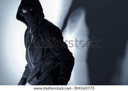 Caucasian Robber in Black Mask and Black Gloves Preparing for Robbery.