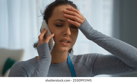 Caucasian sad frustrated sport woman female athlete girl lady complain bad result weight loss check measure tape upset displeased annoyed talking mobile phone home workout slimming overweight problem - Powered by Shutterstock