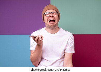 Caucasian Sad Man Holding His Phone, He Is Crying Because He Lost His Job. Studio Shot