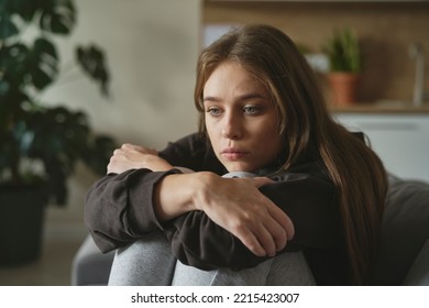 Caucasian sad woman sitting at the sofa with depression - Shutterstock ID 2215423007