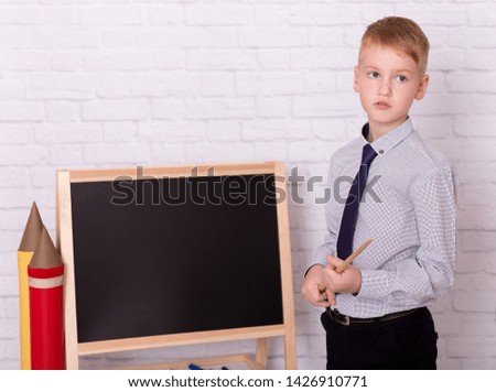  Caucasian schoolboy  is holding a pointer.  Back to school.  