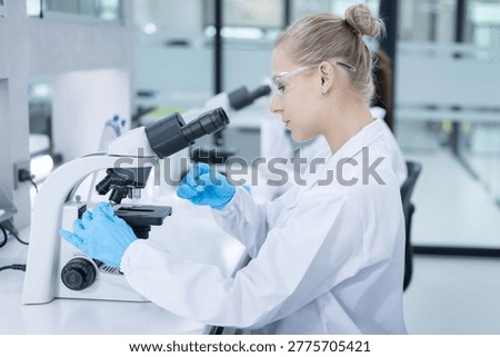 Caucasian scientist looking through a microscope in a laboratory