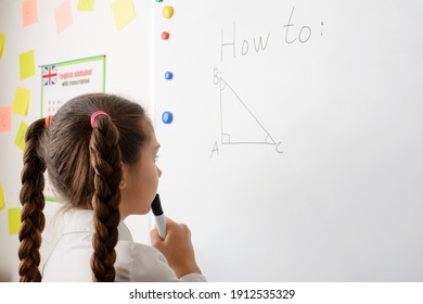 Caucasian secondary school learner doing geometrical task on the board, thinking about the Pythagorean theorem. Lesson of geometry - Powered by Shutterstock