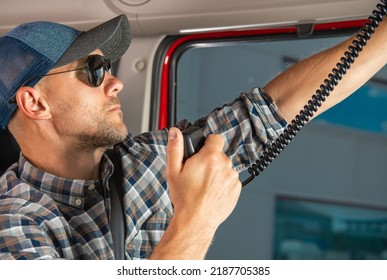 Caucasian Semi Truck Driver Browsing CB Radio Channels. Truck Convoy Communication Equipment. Transportation Industry.