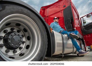 Caucasian Semi Truck Driver In His 30s And His Brand New Red Tractor Truck. Heavy Duty Transportation Theme.