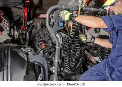 Caucasian Semi Truck Mechanic Performing Diesel Engine Maintenance With Scheduled Checkup. Transportation Industry Theme.