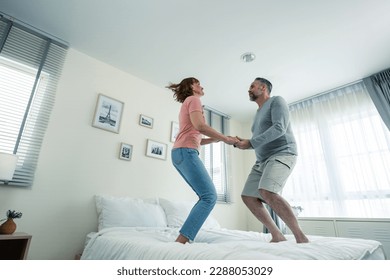 Caucasian senior couple dancing with music together in bedroom at home. Elderly older grandfather and grandmother smiling, feeling in love and enjoy relationship and activity in house after retirement - Powered by Shutterstock