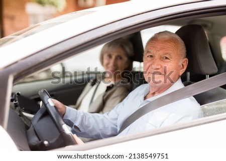 Caucasian senior couple sitting in car. Old man sitting on driver's seat.