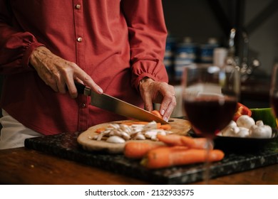 Caucasian Senior Female Chopping Vegetables In Kitchen