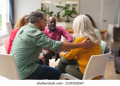 Caucasian Senior Man Consoling Crying Female During Group Therapy Session. Unaltered, Support, Alternative Therapy, Community Outreach, Mental Wellbeing And Social Gathering.