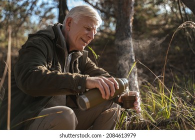 Caucasian senior man pouring hot beverage to mug from the thermos - Powered by Shutterstock