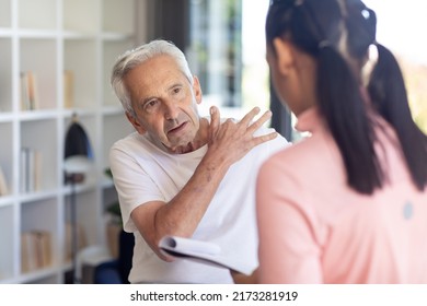 Caucasian senior man showing his shoulder pain problem to biracial female physiotherapist. Physiotherapy and rehabilitation concept - Powered by Shutterstock