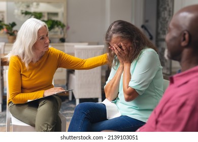 Caucasian Senior Woman Consoling Depressed Female During Group Therapy Session. Unaltered, Support, Alternative Therapy, Community Outreach, Mental Wellbeing And Social Gathering.