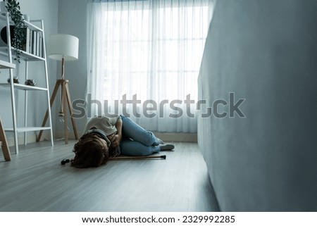 Caucasian senior woman fall on the ground alone in living room at home. Elderly older mature grandmother having an accident lying on floor after doing physical therapy alone after retirement in house.
