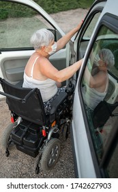 Caucasian Senior Woman In A Wheelchair Getting Into A Car