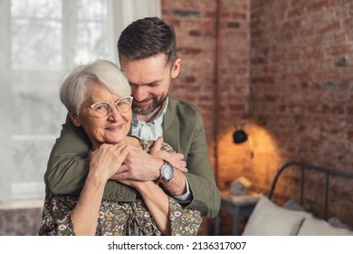 caucasian smartly dressed millennial man being affectionate with his elderly pensioner mother. High quality photo - Powered by Shutterstock