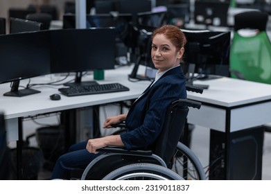 Caucasian smiling woman in wheelchair at work desk.  - Powered by Shutterstock