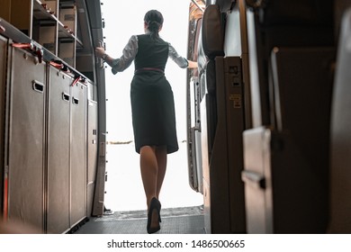 Caucasian Stewardess Opening Door In Airplane Stock Photo. Airways Concept