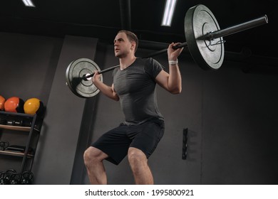 Caucasian Strong Athletic Man Having Workout And Bodybuilding With Barbells Weight Back Squat Setting Style In Gym And Fitness Club. Dark Background. Crossfit Concept