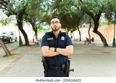 Caucasian Strong Police Officer On Duty Part Of The Law And Order Preventing Injustice And Crime On The City Park