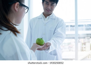 Caucasian Student Gave A Green Apple To The Science Teacher, Selective Focus 