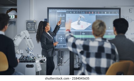 Caucasian Student Girl Raise Her Hand and Asking Teacher Standing Near the Big Screen. Teenagers Studying Robotic Arm at the Lesson In Modern University of Technology. Machine Learning Concept - Powered by Shutterstock