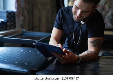 Caucasian Tattoo Artist Talking By Mobile Phone And In Tattoo Studio