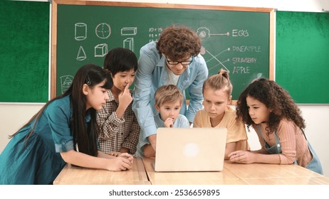 Caucasian teacher and diverse student looking at laptop at classroom. Cute multicultural children learning about coding program or generated program by using software while teacher teaching. Pedagogy. - Powered by Shutterstock