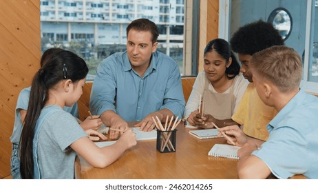 Caucasian teacher and smart boy discuss about project at classroom. Professional instructor talking about classwork while giving a paper to highschool child with diverse student listen. Edification. - Powered by Shutterstock