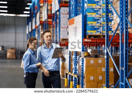 Caucasian team man and woman worker working at warehouse factory. Warehouse staff worker standing by goods shelf working in large warehouse Stock foto © 