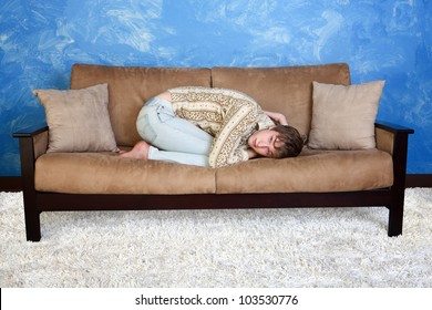 Caucasian Teen In Curled Up Position On Sofa